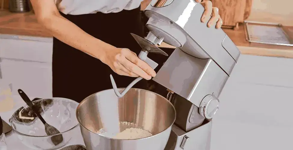 person adjusting dough hook on commercial mixer